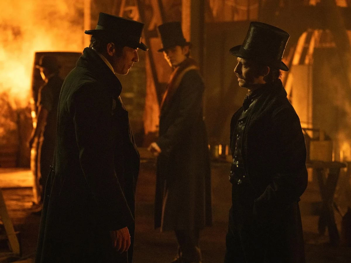 Escena de la serie La casa Guinness de Netflix en la que aparecen dos personajes con chistera conversando de noche en mitad de la calle