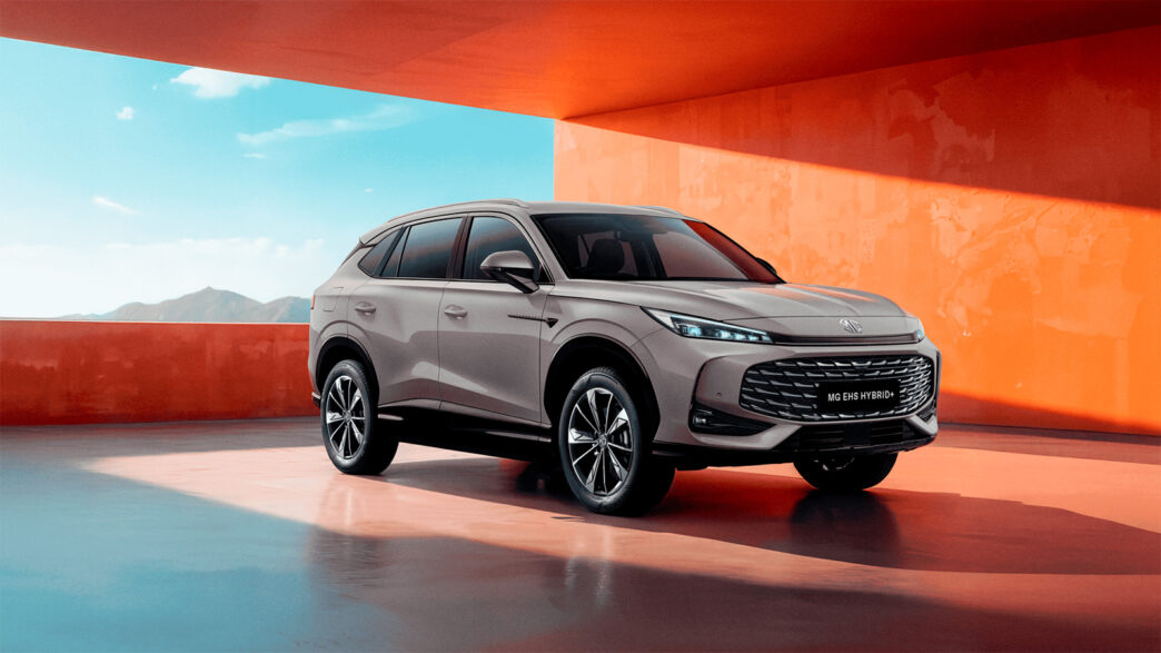 Vista frontal y lateral del MG HS Hybrid+ 2025 en color gris con parrilla de gran tamaño y faros LED.
