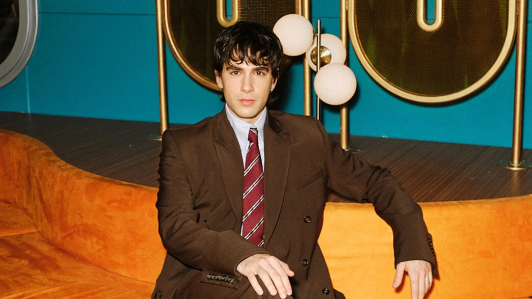El actor Pau Simon vestido de traje en el set de rodaje de la serie El Refugio Atómico de Netflix