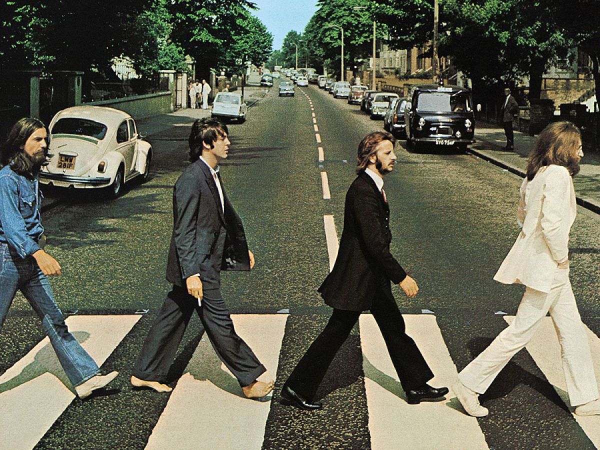 Mítica imagen de Los Beatles cruzando por un paso de cebra vestidos de traje