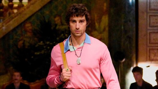 El actor Agustín della Corte desfilando para Versace con un jersey rosa chicle y un polo azul