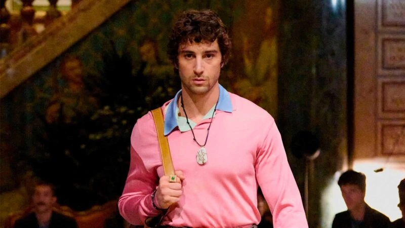 El actor Agustín della Corte desfilando para Versace con un jersey rosa chicle y un polo azul