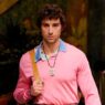 El actor Agustín della Corte desfilando para Versace con un jersey rosa chicle y un polo azul