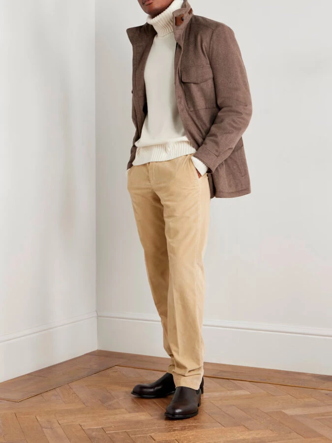 Hombre con pantalón beige de pana, jersey blanco y rebeca camel tipo blazer