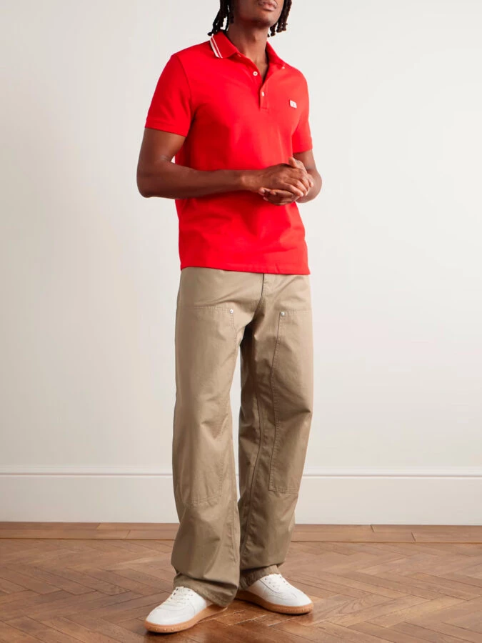 Look deportivo con pantalón beige ancho, polo rojo y zapatillas blancas