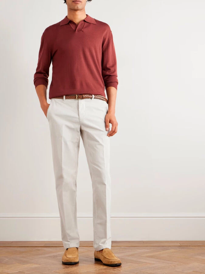 Hombre con pantalón beige recto, polo burdeos y mocasines de ante camel