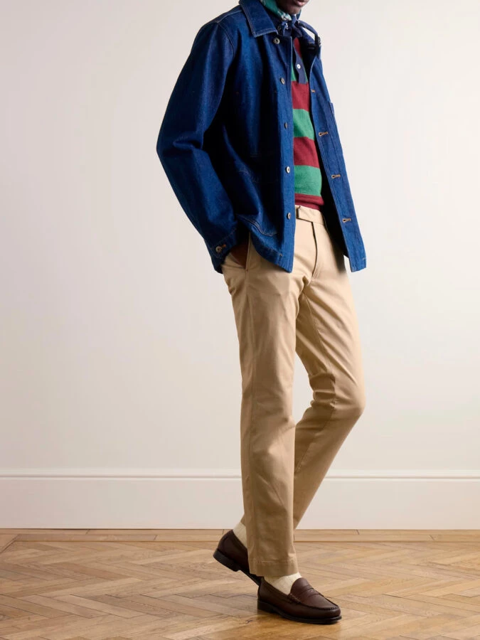Hombre con pantalón beige, polo de rayas y sobrecamisa vaquera