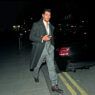 El modelo David Gandy caminando por la calle, de noche vestido muy elegante con traje y un abrigo largo