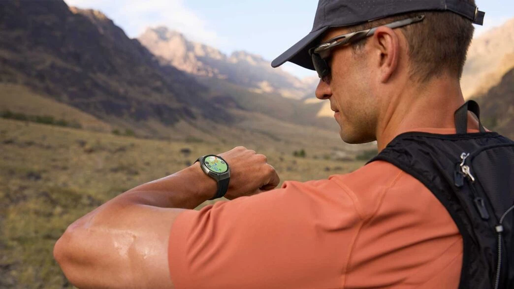 Hombre consultando su reloj Huawei en una ruta al aire libre