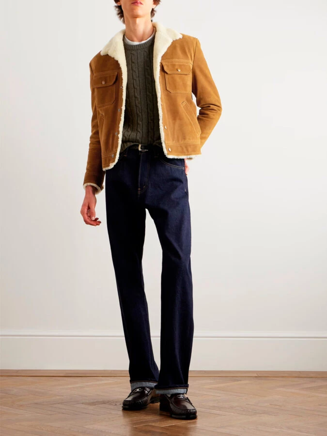 hombre vestido con una cazadora de ante marrón miel con pantalones vaqueros oscuros y un jersey verde de lana