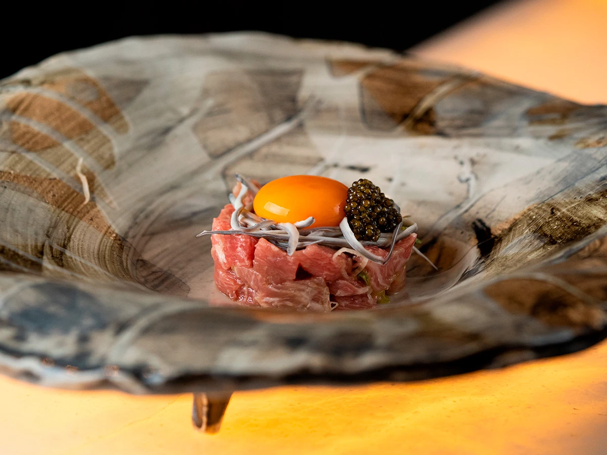 Huevos rotos con atún toro, gulas, yema curada y caviar, plato icónico del restaurante Ricardo Sanz Wellington.