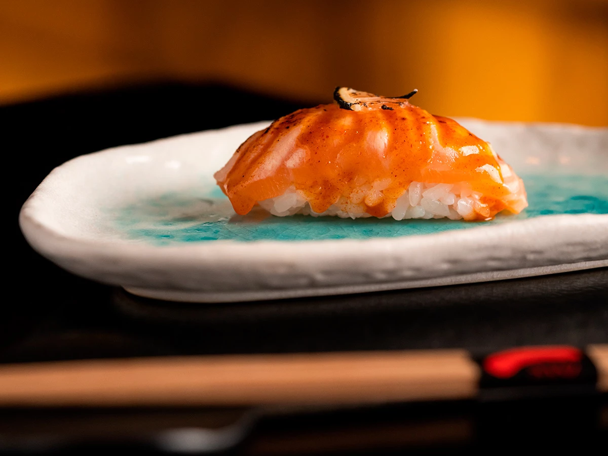 Niguiri de salmón braseado con salsa especial y lámina de trufa en el restaurante Ricardo Sanz Wellington.