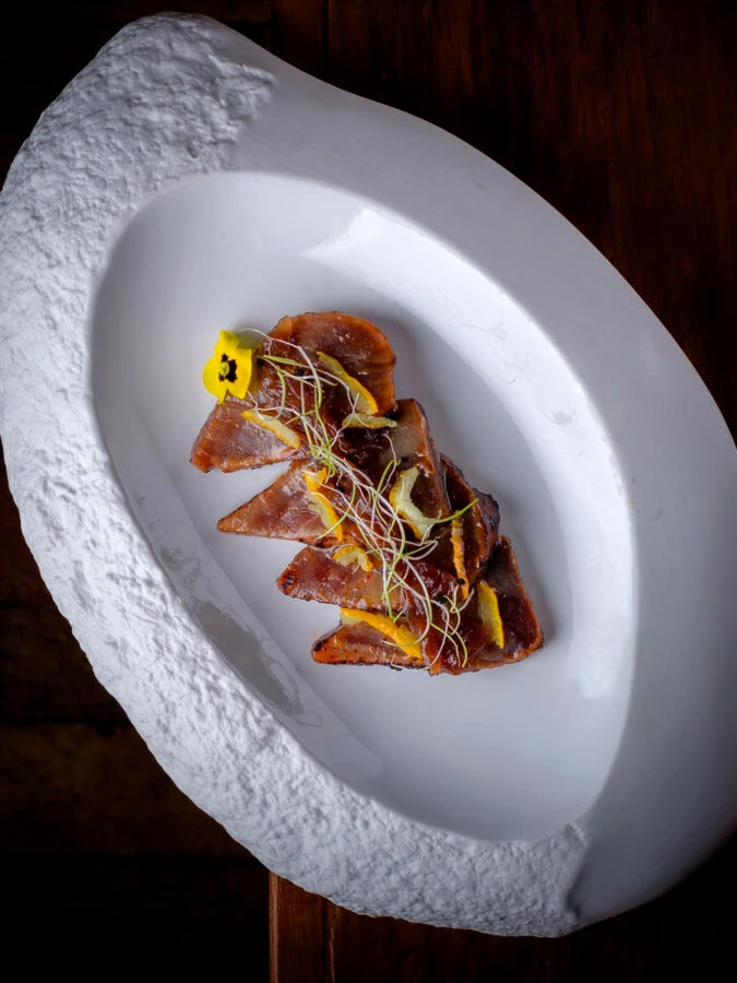 Tataki de vaca premium servido en plato ovalado en el restaurante Yugo The Bunker de Madrid.