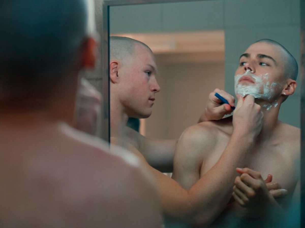 Secuencia de la serie de temática LGBT "Boots" en la que se puedever a dos chicos jóvenes en un baño, mientras uno de los chicos afeita al otro frente a un espejo