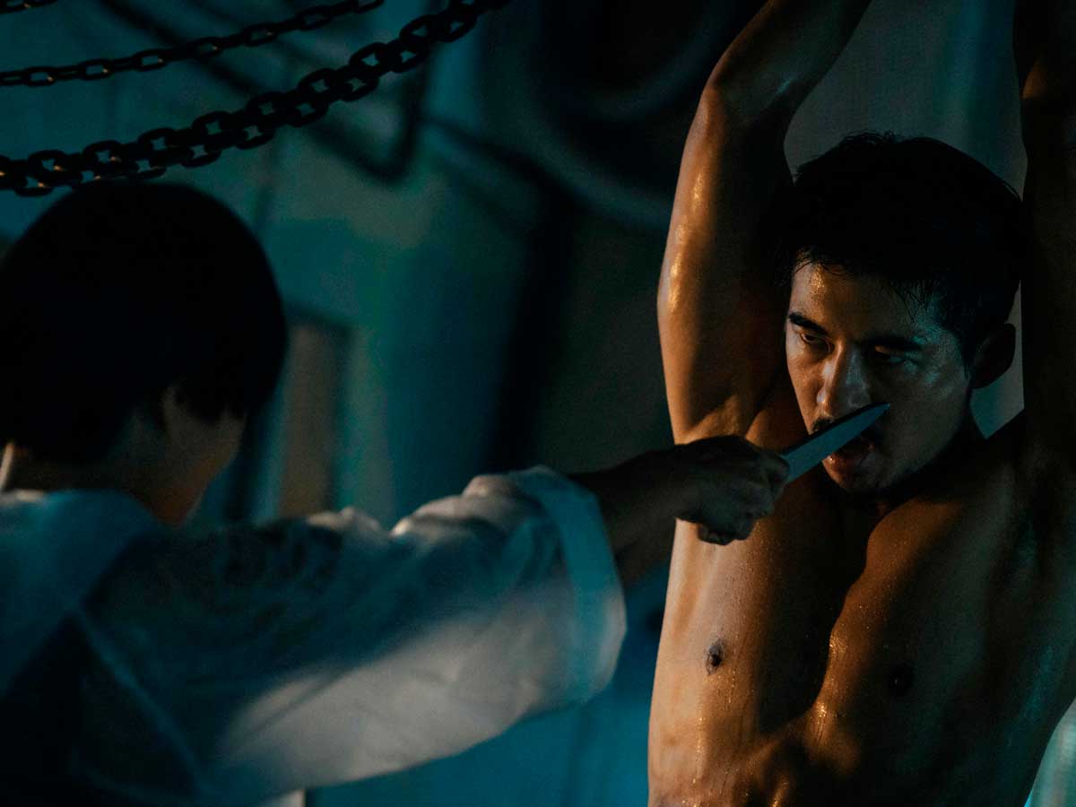 Secuencia de la serie de terror taiwanesa The Resurrected en la que se ve a un hombre colgando de los brazos y a una mujer apuntándolo con un cuchillo