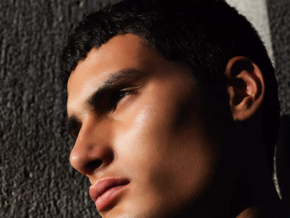 Primer plano de Alejo Humanes con luz natural destacando sus facciones en una sesión de moda masculina para Rísbel Magazine.
