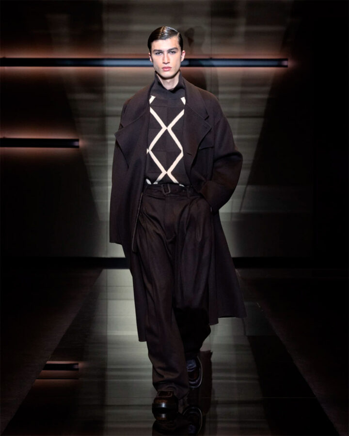 Modelo con jersey de rombos negro y beige de Emporio Armani en el desfile otoño/invierno 2025.