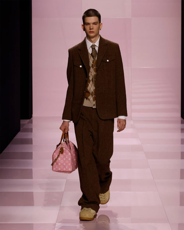 Modelo con conjunto marrón y chaleco de rombos en el desfile masculino de Louis Vuitton otoño/invierno 2025.