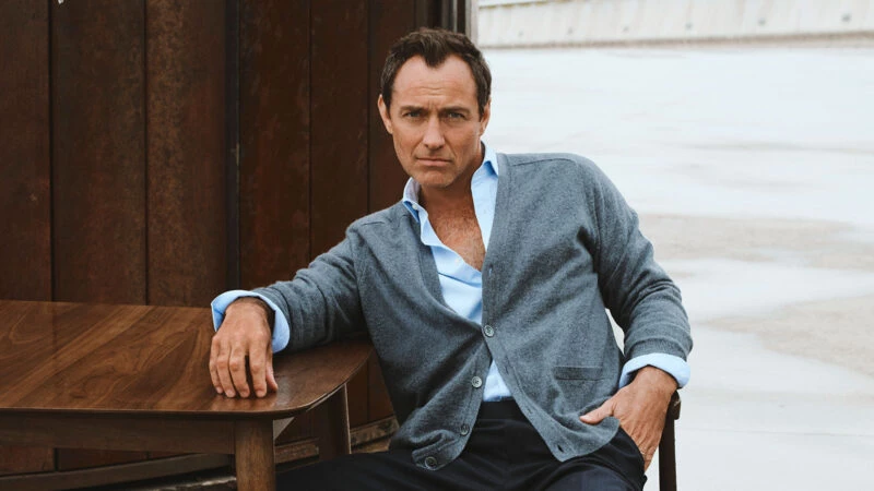 Jude Law con cárdigan gris y camisa abierta en la campaña de Emidio Tucci otoño-invierno 2025