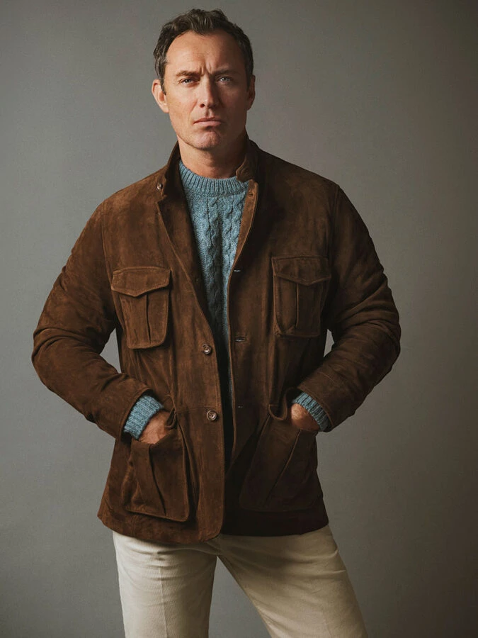 Jude Law con chaqueta de ante marrón y jersey azul de ochos en la campaña de Emidio Tucci.
