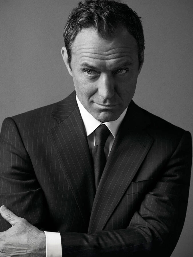 Retrato en blanco y negro de Jude Law con traje de raya diplomática para Emidio Tucci.