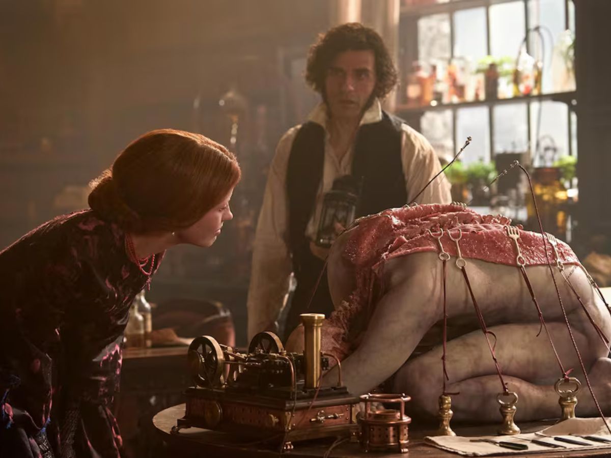 Escena de la película Frankestein en la que se ve a Elisabesth Lavenza (Mia Goth) examinando un cuerpo muerto encima de una mesa.