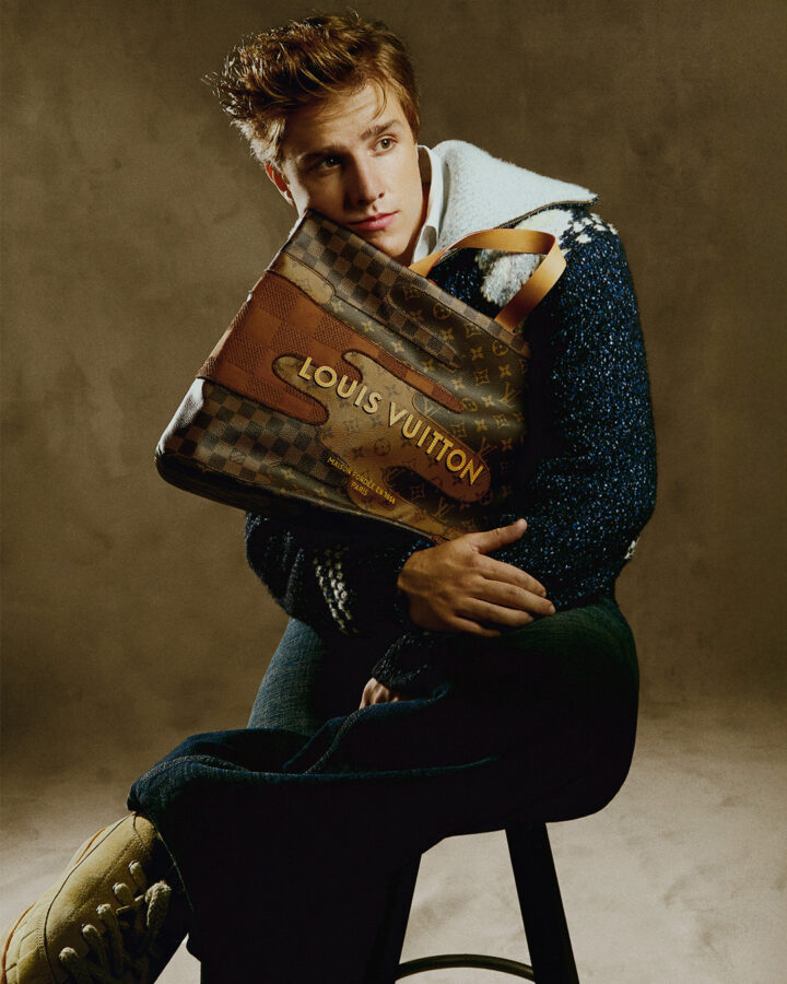 El actor Nuno Gallego sentado en un taburete con el rostro sobre un bolso de Louis Vuitton. Sesión de fotos para Rísbel Magazine.