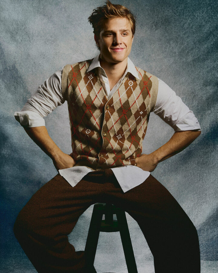 El actor Nuno Gallego, sentado en un taburete en un estudio de fotografía, posa en exclusiva en una sesión de fotos para la revista Rísbel, vestido con ropa Louis Vuitton