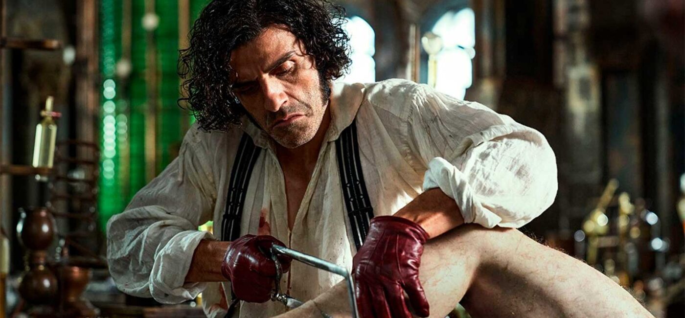 El actor Oscar Isaac en una escena de la película Frankestein, en la que se le ve amputando una pierda a un cadáver
