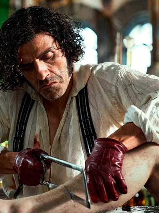 El actor Oscar Isaac en una escena de la película Frankestein, en la que se le ve amputando una pierda a un cadáver
