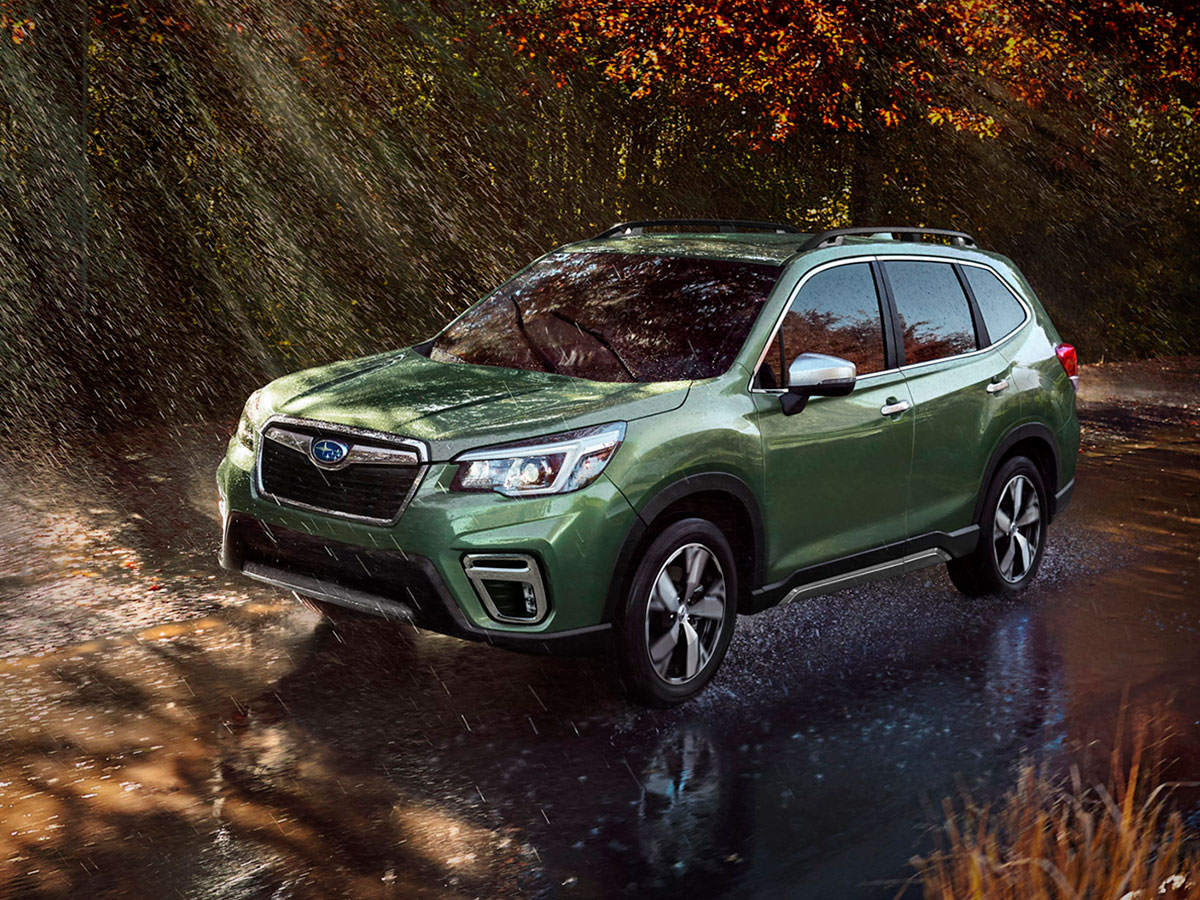 Coche Subaru verde en mitad de un bosque