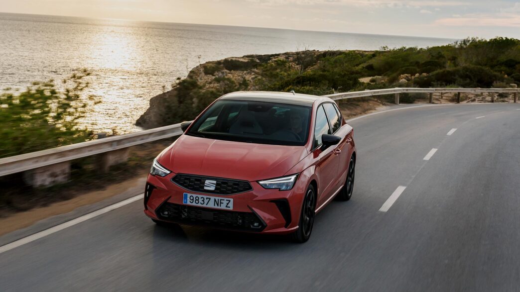 SEAT Ibiza 2025 en color rojo circulando por carretera junto al mar