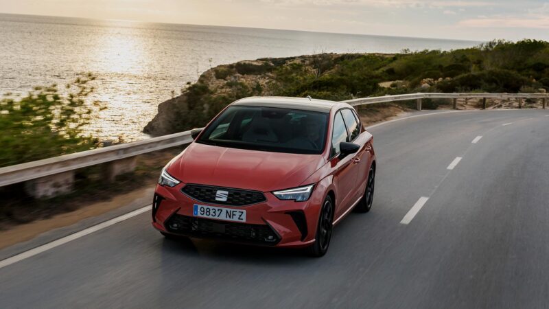 SEAT Ibiza 2025 en color rojo circulando por carretera junto al mar