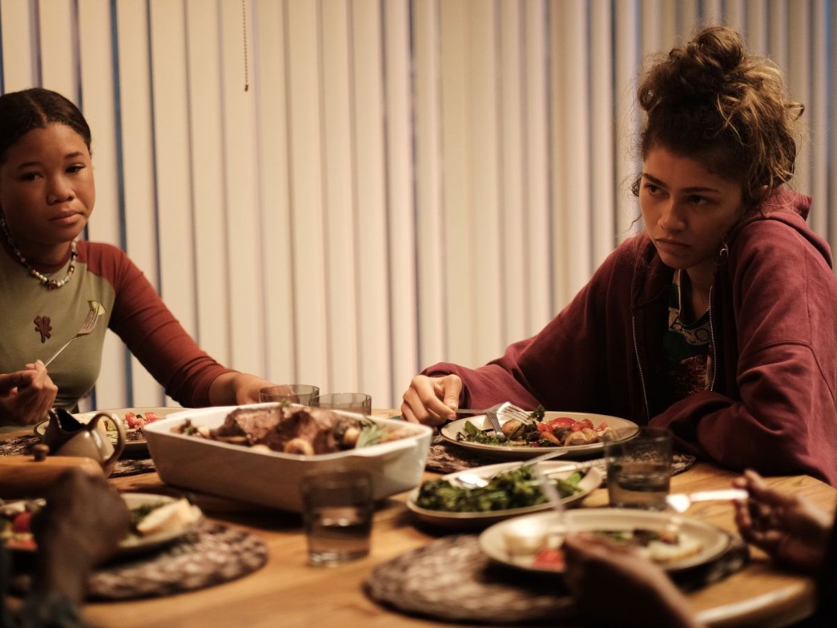 La actriz y cantante Zendaya en una escena de la tercera temporada de Euphoria en la que aparece comiendo sentada en una mesa.