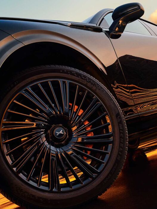 Vista lateral del Xpeng G9 2025 en color negro sobre una carretera de montaña.