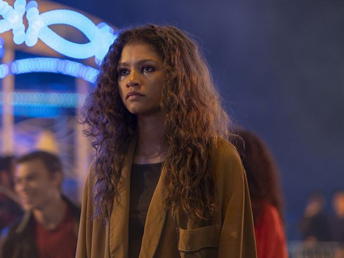 Zendaya interpretando a Rue en la tercera temporada de Euphoria bajo una iluminación violeta característica de la serie.