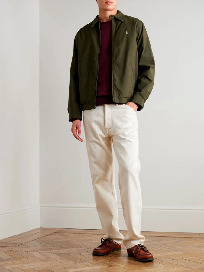 Look de hombre con jersey granate, chaqueta verde oliva, vaqueros blancos y náuticos marrones