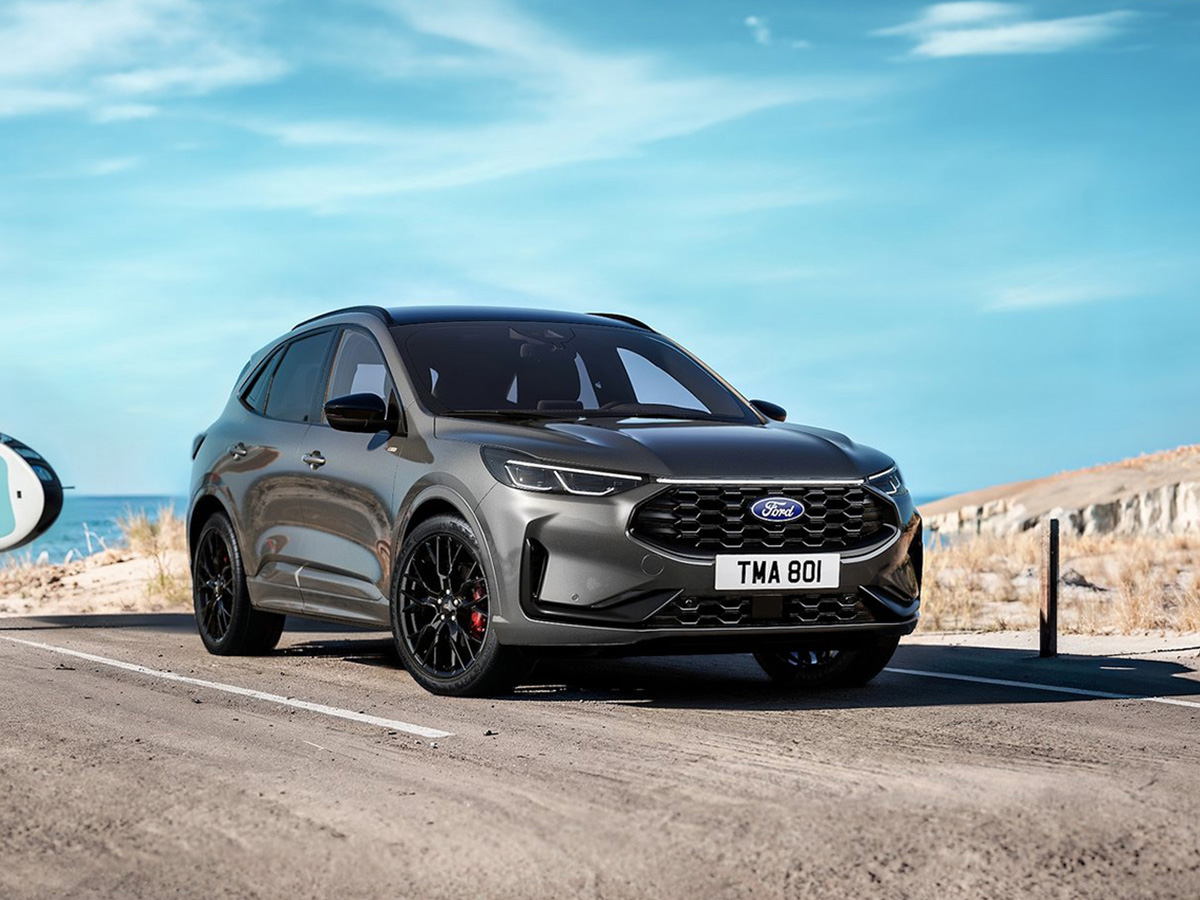 Fotografía del Ford Kuga AWD en color gris oscuro circulando por una carretera de campo.