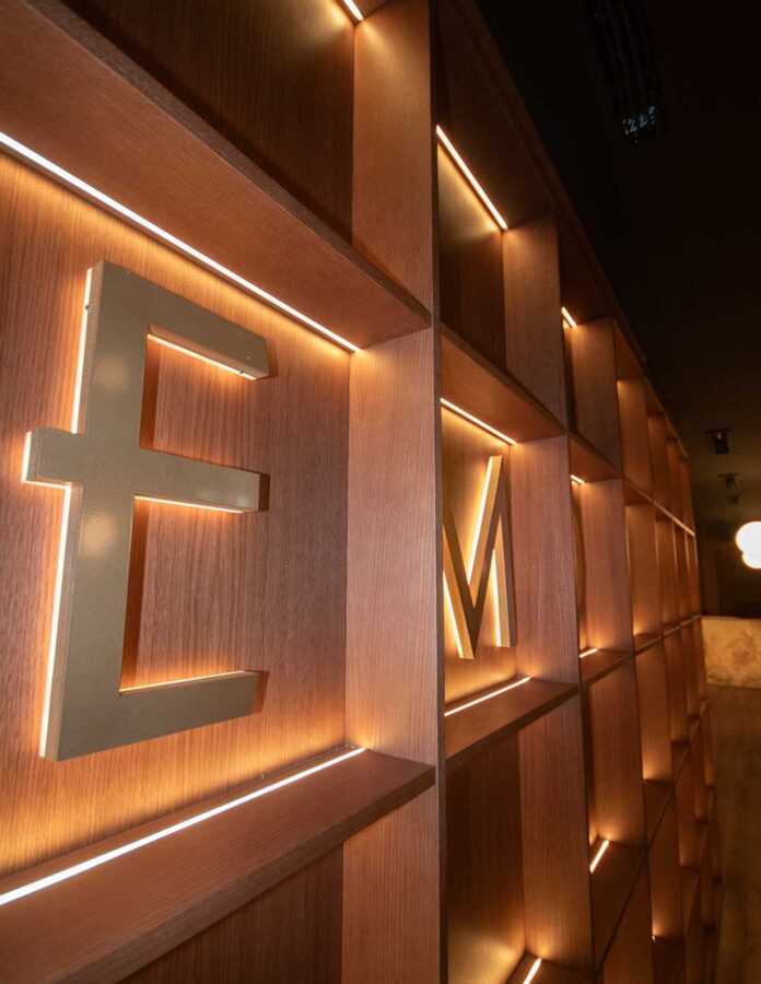 Detalle del interior del restaurante Memories en Madrid con letras retroiluminadas sobre paneles de madera.