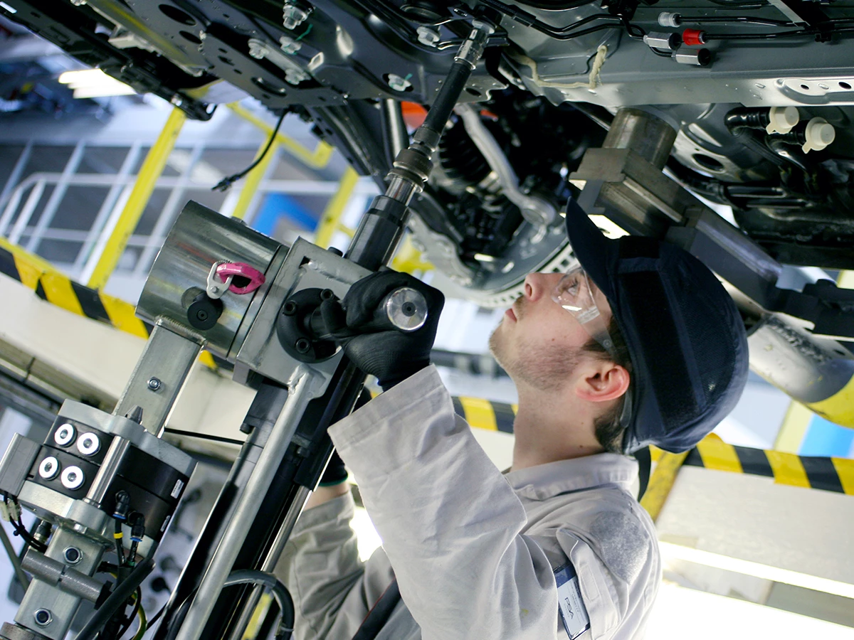 técnico fabricando un coche en una fabrica de coches