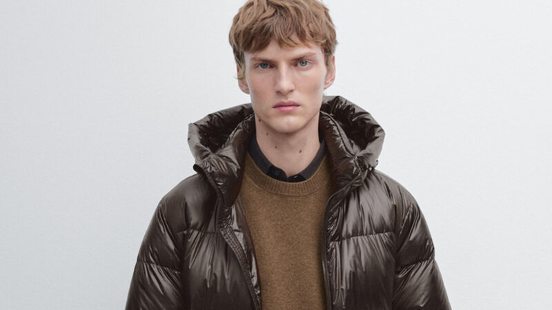 Modelo luciendo abrigo de plumón marrón de Massimo Dutti con capucha y cuello alto.