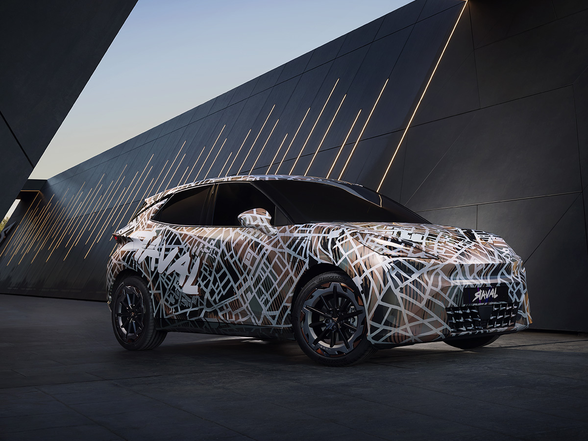 Cupra Raval preserie posando frente a una fachada moderna iluminada, aún con camuflaje.