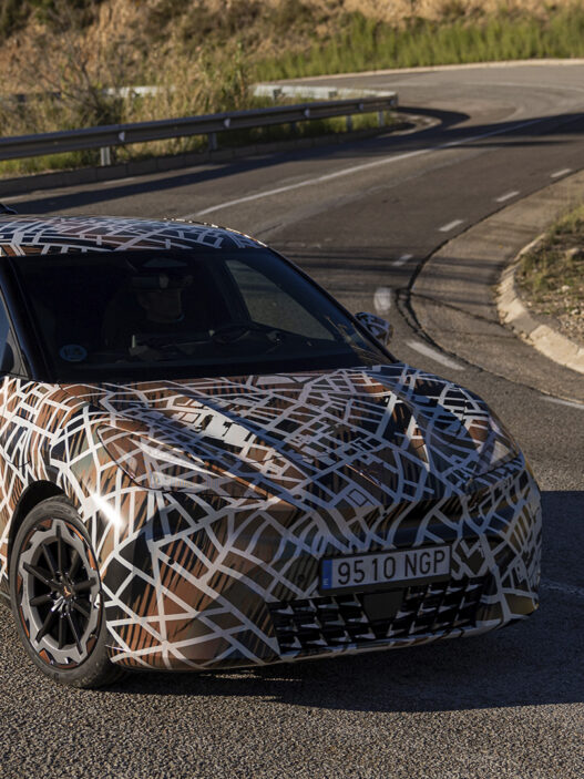 Vehículo preserie del Cupra Raval recorriendo una carretera de montaña durante las pruebas de conducción.