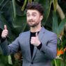 Daniel Radcliffe vestido con un traje gris y levantando los pulgares