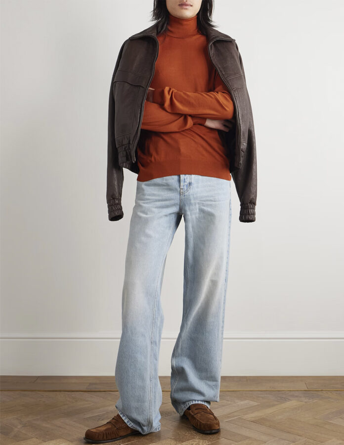 Hombre con jersey rojo tostado, cazadora marrón y vaquero claro de Saint Laurent