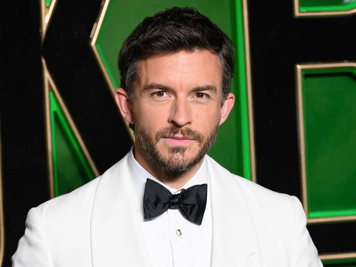 Retrato de Jonathan Bailey vestido de esmoquin blanco con pajarita negra