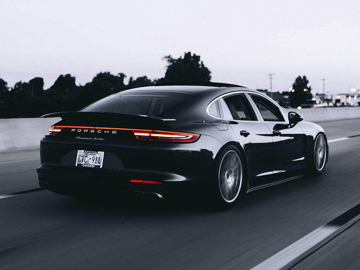 Porsche Panamera Turbo negro circulando por carretera, símbolo del lujo deportivo alemán en 2025.