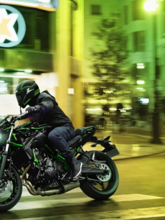 hombre conduciendo una moto por la ciudad de noche