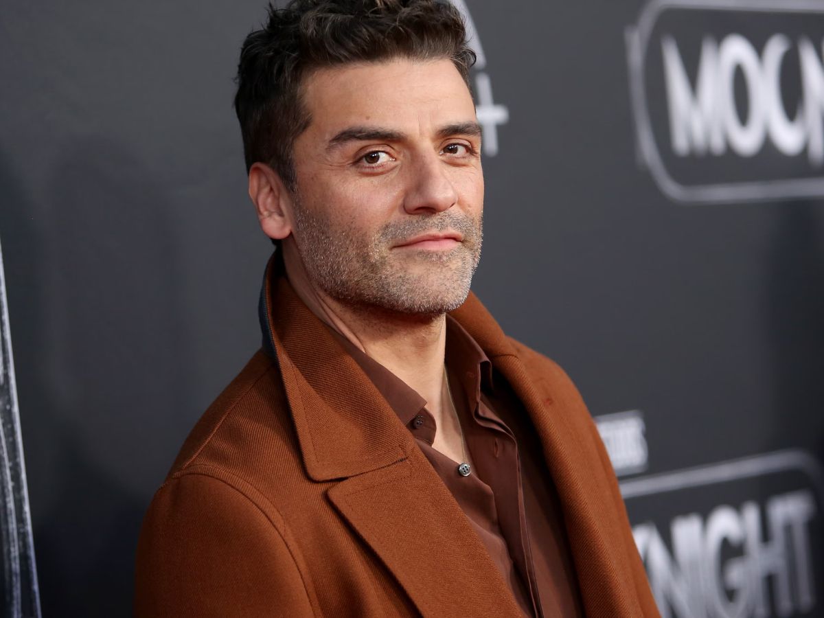 El actor oscar Isaac, afeitado y con el pelo corto frente a un photocall.