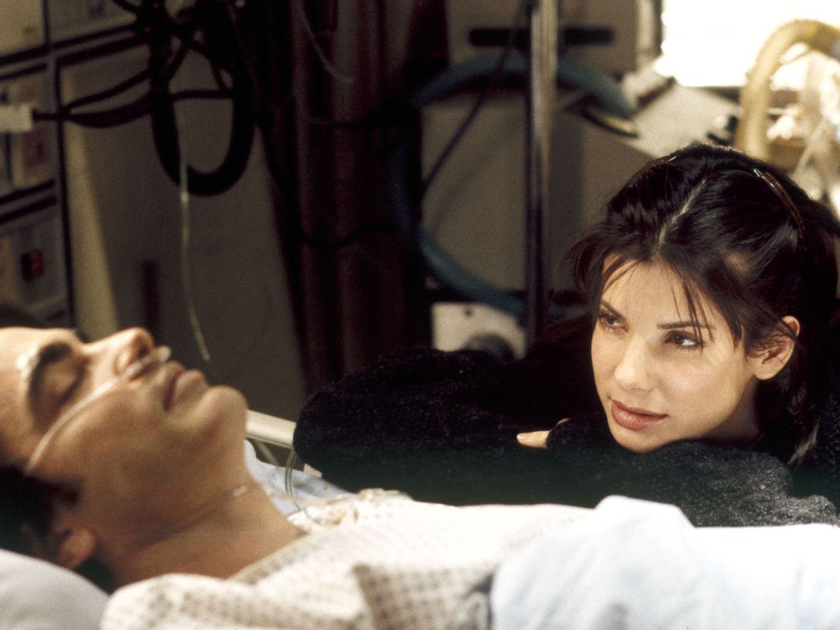 Sandra Bullock junto a un paciente hospitalizado en “Mientras dormías”, película romántica de los 90